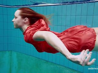 Rosso lungo abito e grande tette floating in il piscina